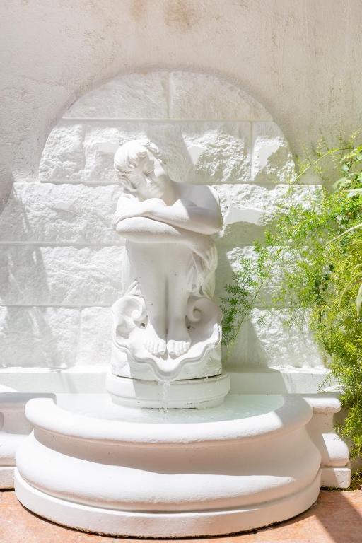 a statue of a woman sitting on a fountain at Orsan Residence Apartment in Dubrovnik