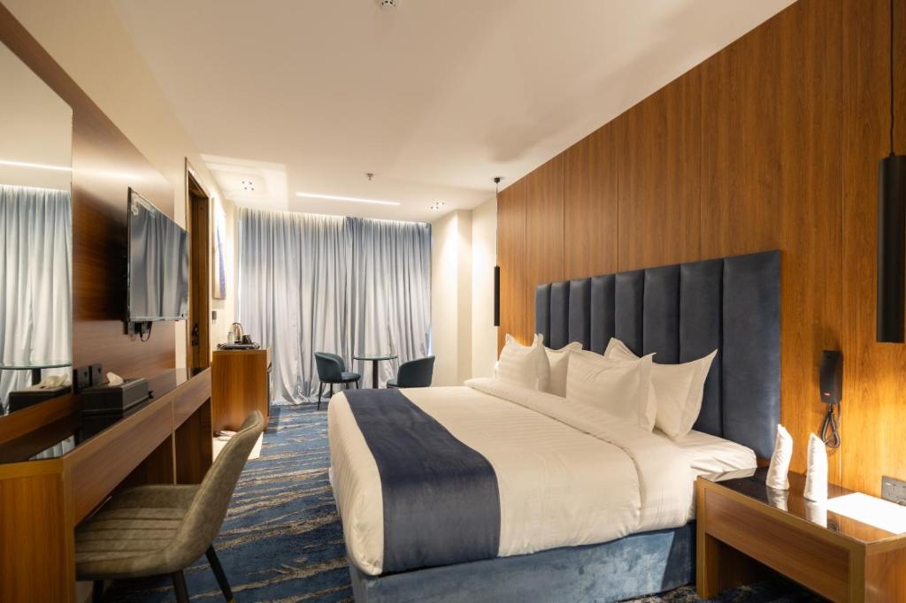 ジッダにあるnasim aizraq hotel فندق نسيم ازرقのベッドと机があるホテルの部屋