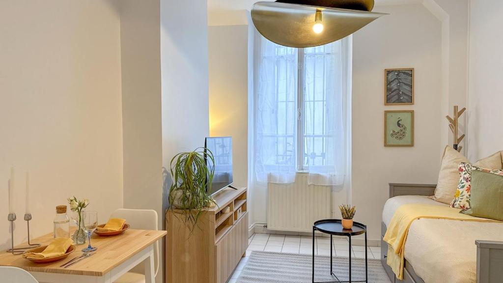 un petit salon avec un lit et une table dans l'établissement Studio Cosy à Deux Pas du Canal, à Paris