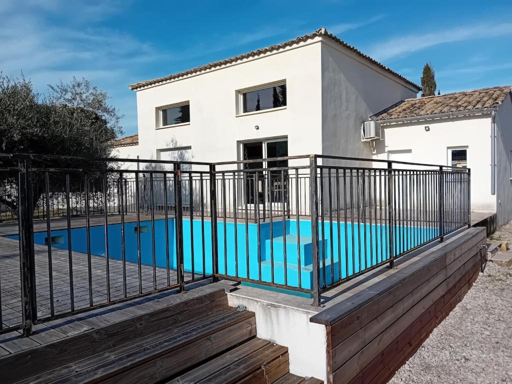 une maison avec une piscine derrière une clôture dans l'établissement Villa Pont du Gard, à Castillon-du-Gard
