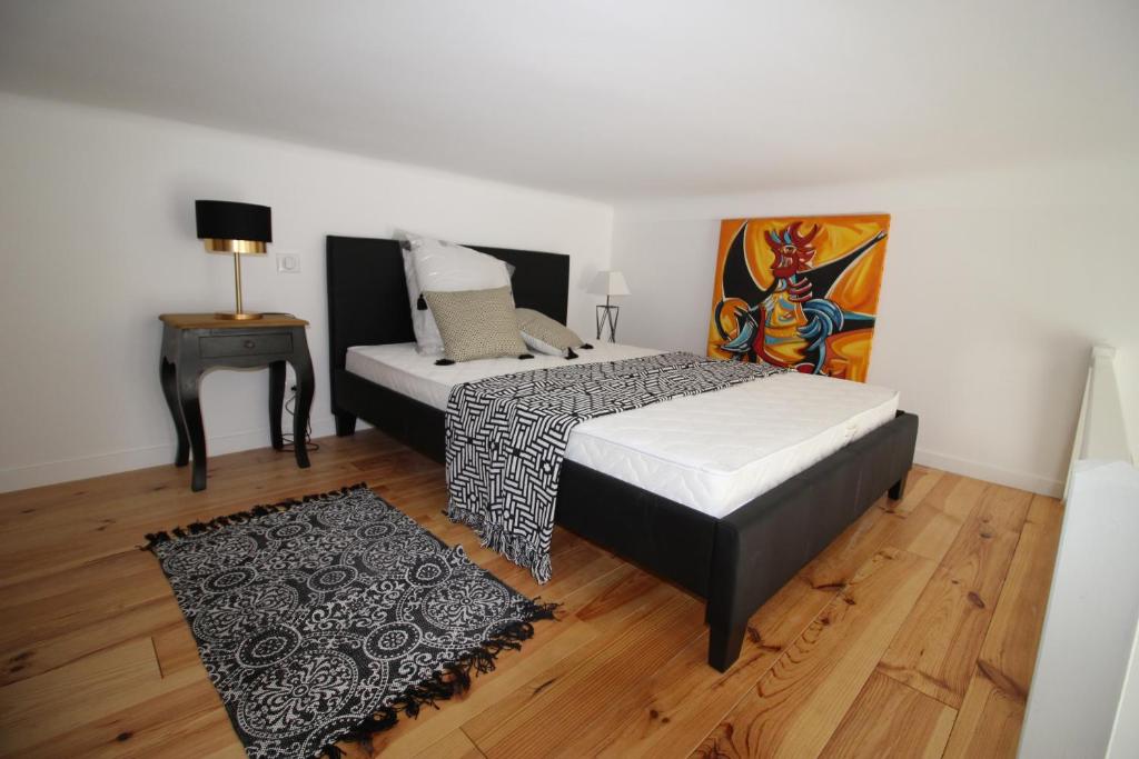 - une chambre avec 2 lits, une table et un tableau dans l'établissement Gioffredo, à Nice