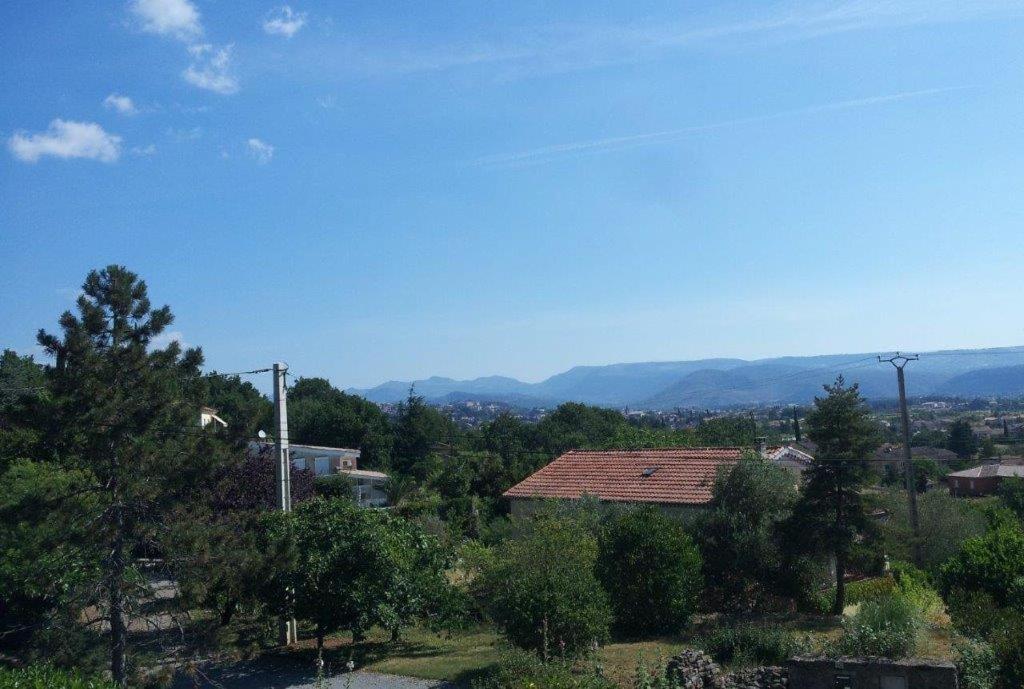 - une vue sur une ville avec des montagnes en arrière-plan dans l'établissement Logement Sud Ardèche, à Saint-Sernin