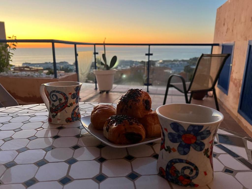 a plate of donuts on a table with two cups at Mojacar Playa Atalaya Résidence in Mojácar