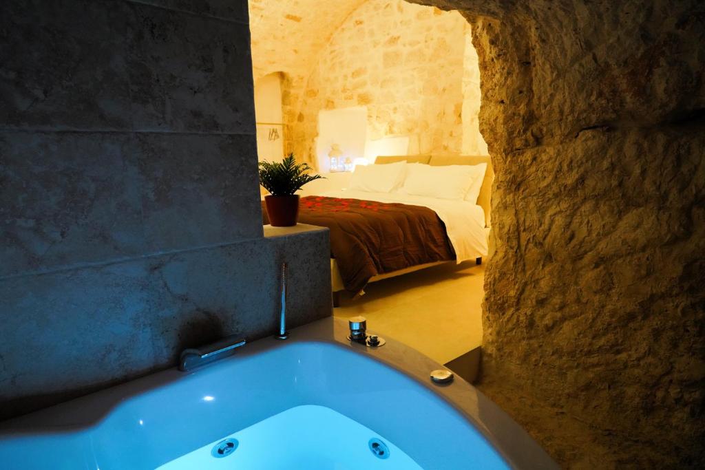 a bathroom with a tub and a bed in a room at Dimora Antica Falegnameria - tra STORIA e RELAX in Ostuni