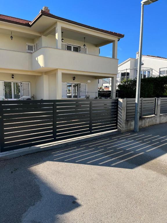 a house with a fence in front of it at Apartments Vido in Vodice