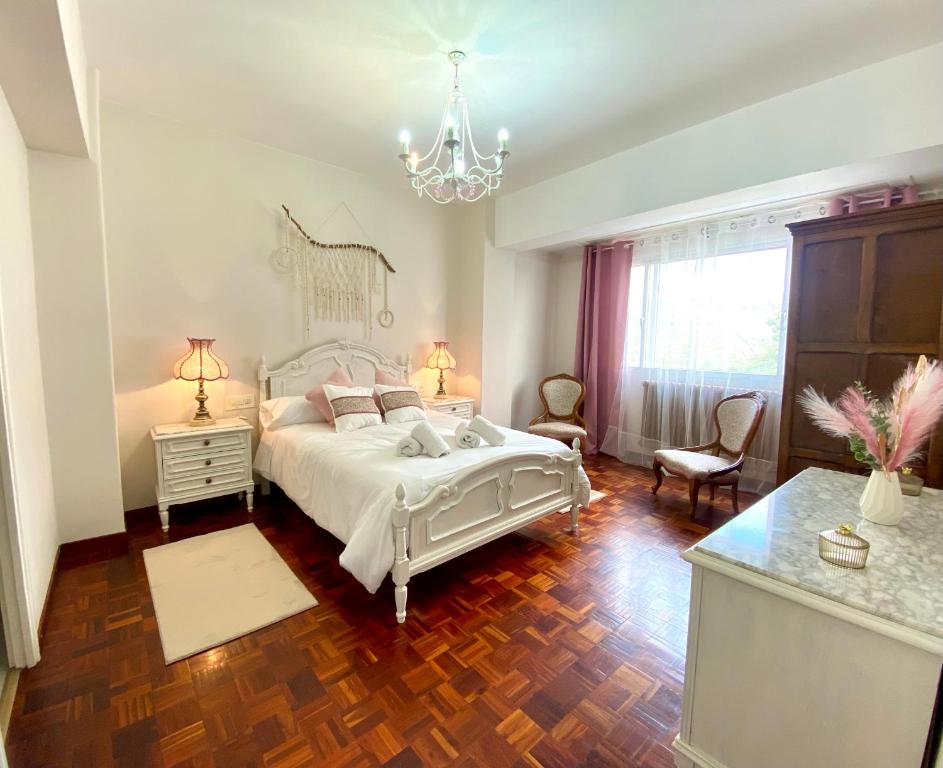 a bedroom with a white bed and a chandelier at Parque de los Condes in Monforte de Lemos
