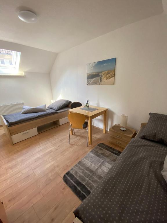 a bedroom with a bed and a desk and a bed and a table at Ferienhaus Hartelt in Ebergötzen