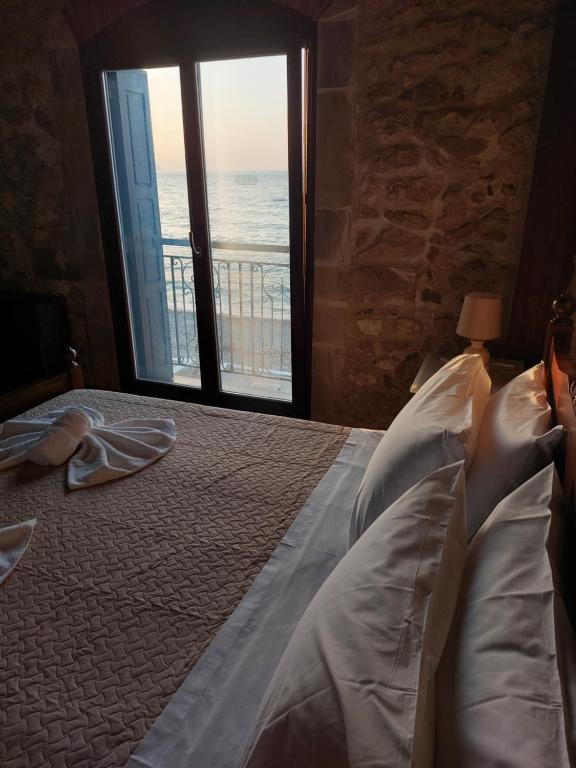 a bedroom with a bed with a view of the ocean at Volakas Beachfront Suites in Rethymno