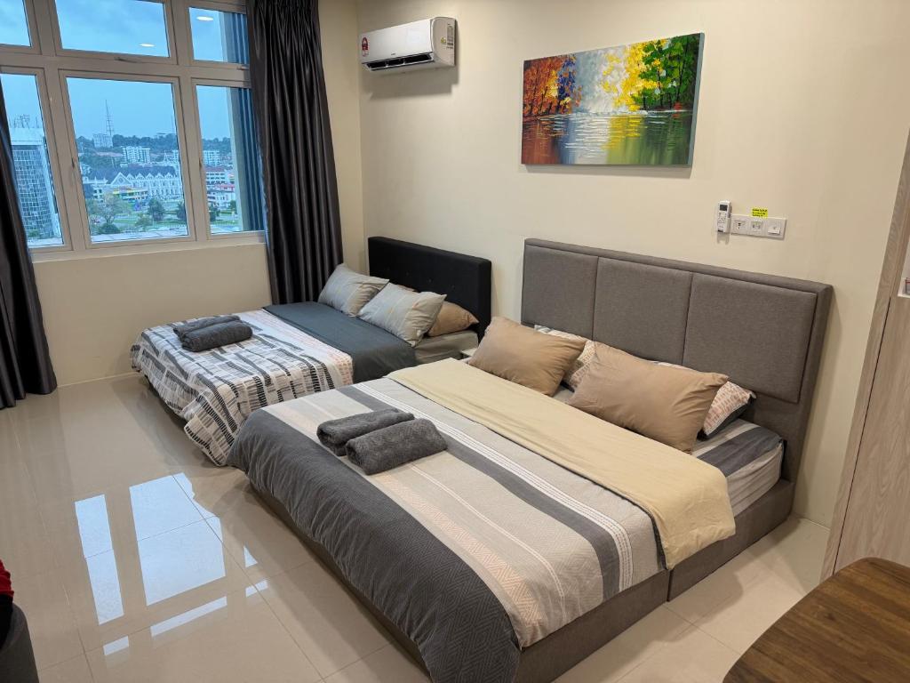 a bedroom with two beds and a window at 4 Pax - Scenic Riverfront Studio B, Kuching City in Kuching