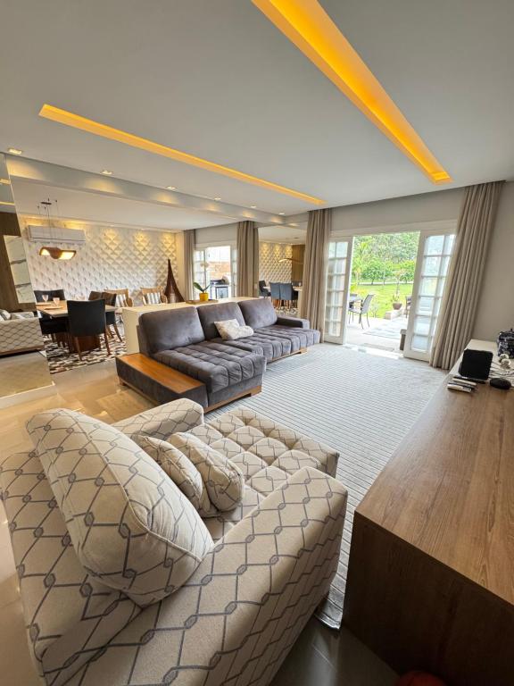 a large living room with a couch and a table at Paraiso na Praia da Enseda in Guarujá