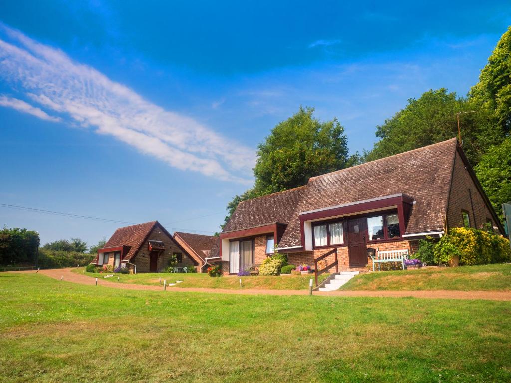 a house with a green lawn in front of it at Glyndley Manor Cottages in Polegate