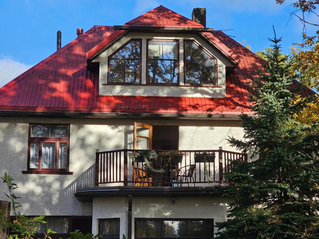 Casa con techo rojo y balcón en White House Apartment, en Jūrmala