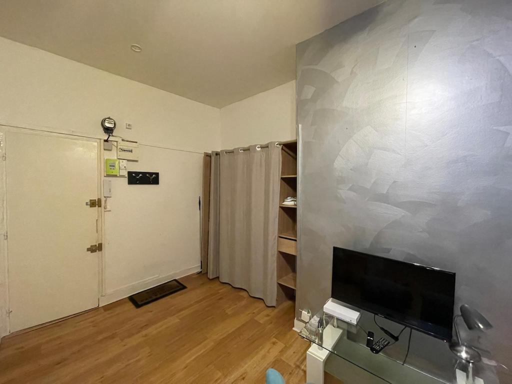 un salon avec une télévision à écran plat sur un mur dans l'établissement Chouette Studio à Bordeaux Centre, à Bordeaux