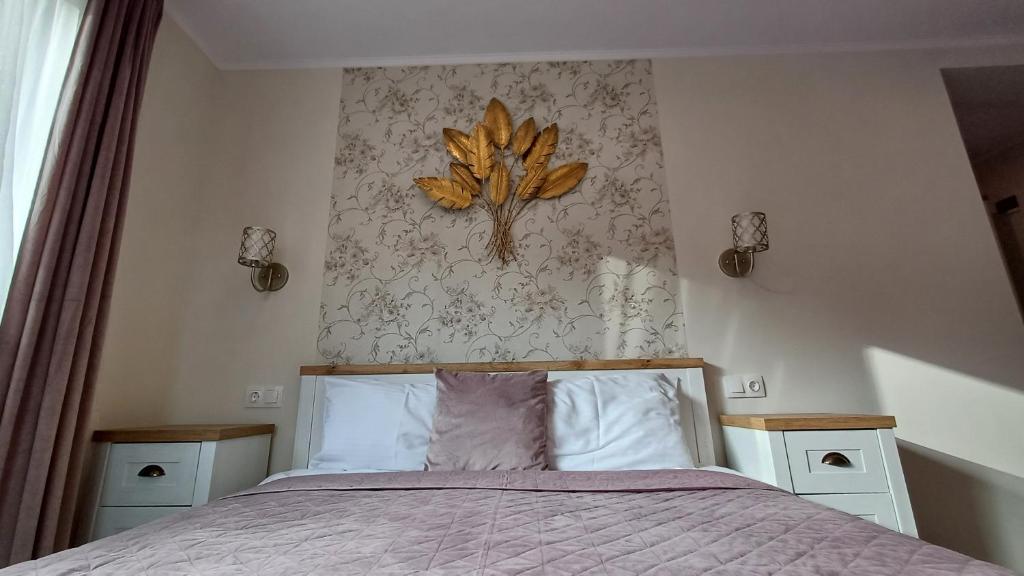 a bedroom with a bed with a leaf on the wall at Nobila Sinaia in Sinaia