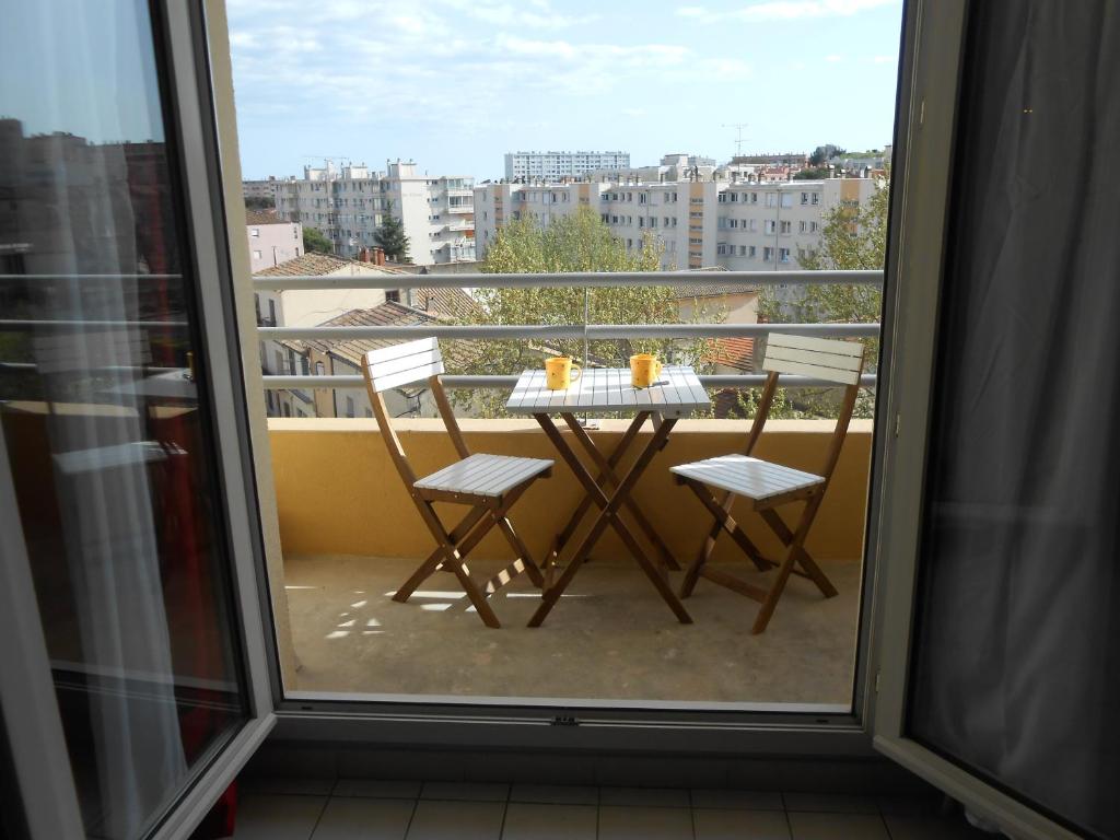 une table et des chaises sur un balcon avec vue dans l'établissement T1 parking et wifi proche centre et station tram, à Montpellier
