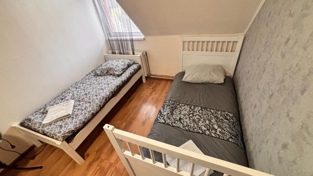 two beds in a small room with a window at Penzion Bilina in Teplice