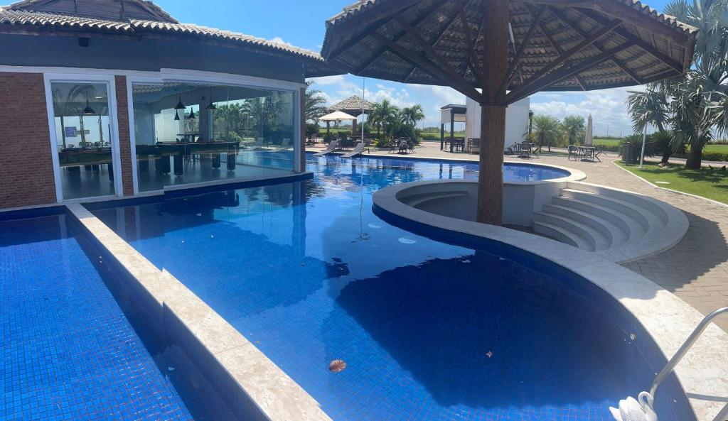 a swimming pool with an umbrella in a resort at Casa Alegria in São-José-do-Ribamar