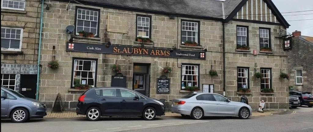 two cars parked in front of a building at St aubyn arms Hotel in Praze an Beeble