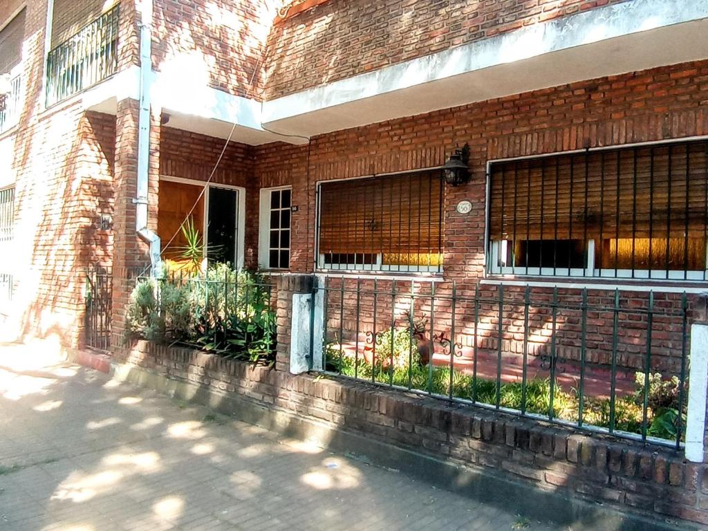 a brick building with a fence on the side of it at Casa Francia in San Isidro