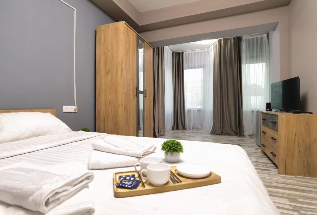 a bedroom with a white bed with a tray of food at Hayq Hotel in Yerevan