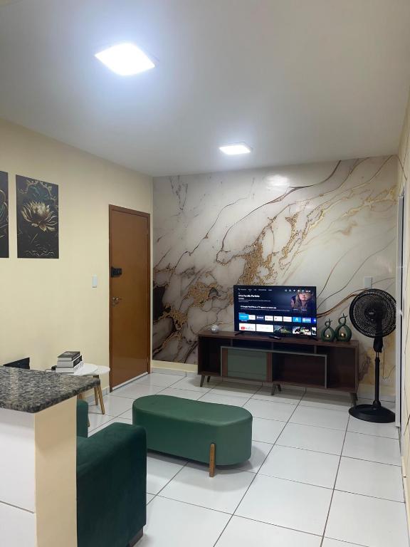 a living room with a large screen tv on a wall at Impera House Ar no dois quartos in Imperatriz