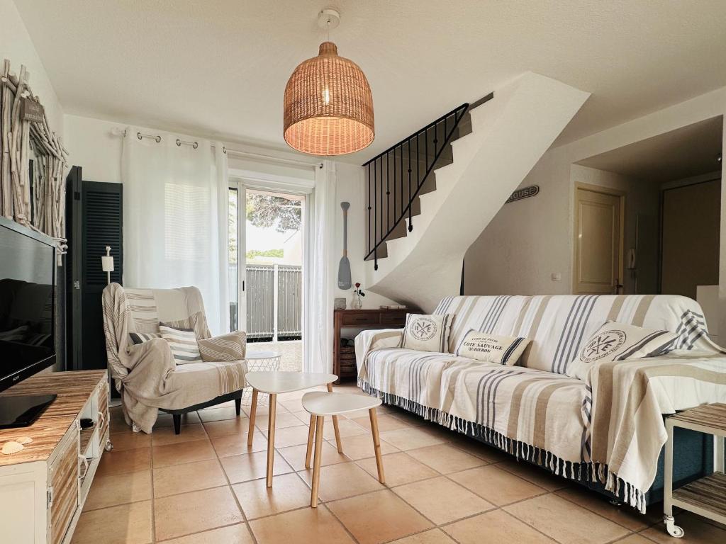 ein Wohnzimmer mit einer Couch und einer Treppe in der Unterkunft Bastide Saint Vincent in Le Grau-dʼAgde