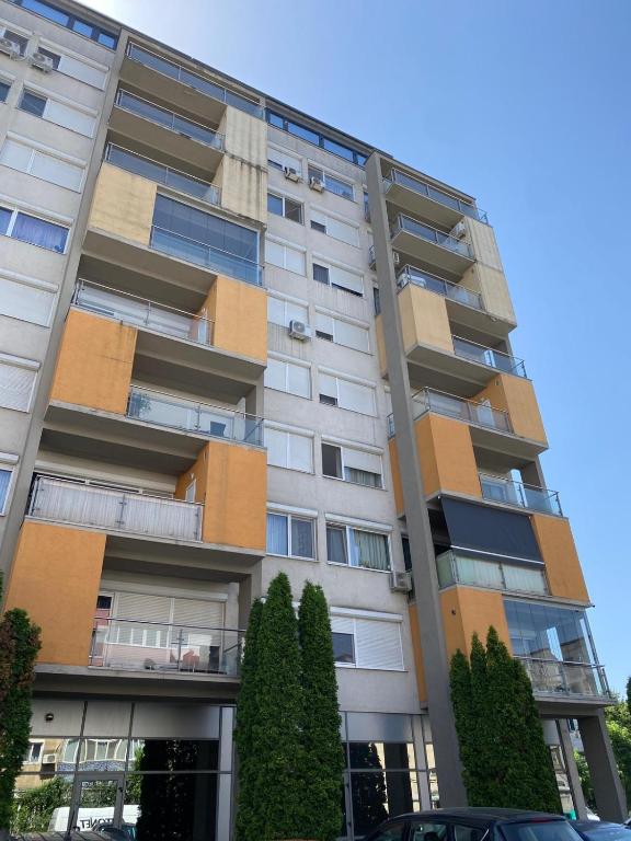 a tall apartment building with trees in front of it at Dulcinea Life in Deva
