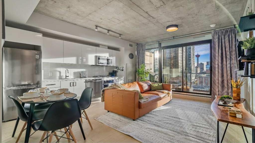 a living room with a couch and a table at Miso 2 BD - Skyline View Patio Gym Pool & AC in Calgary