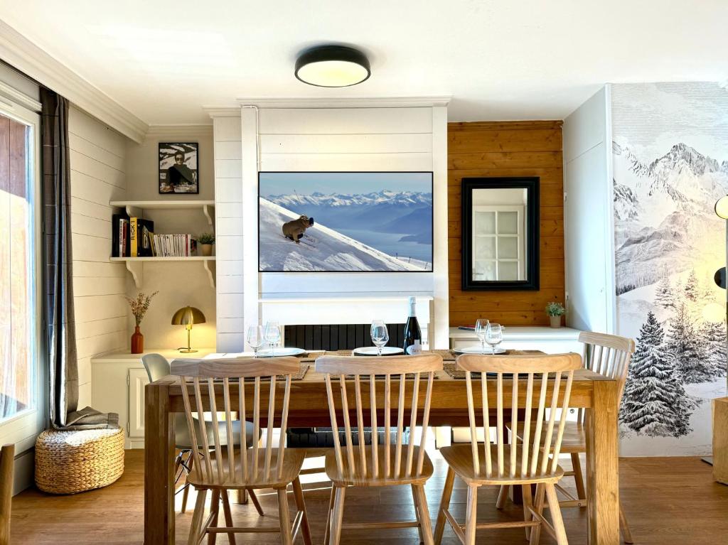 a dining room with a wooden table and chairs at Appartement 6 8 personnes, balcon vue montagne, ski aux pieds in Val Thorens