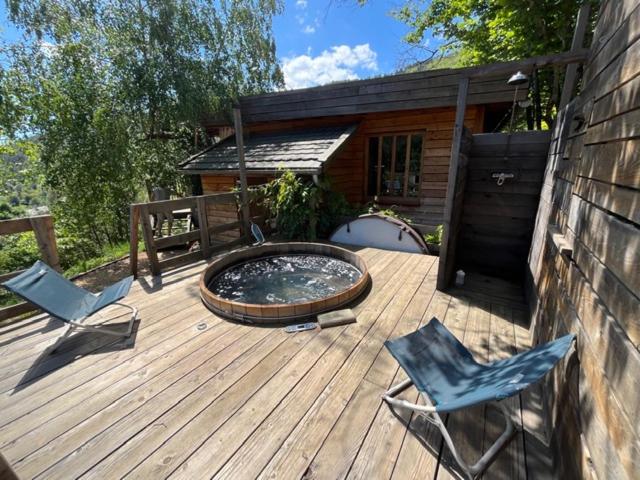 une terrasse avec deux chaises et un bain à remous dans l'établissement Les gîtes de Sainte Croix, à Sainte-Croix-Vallée-Française