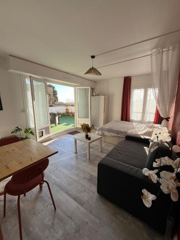 une chambre avec un lit, un bureau et une table dans l'établissement Studio et terrasse près de Paris, à Suresnes