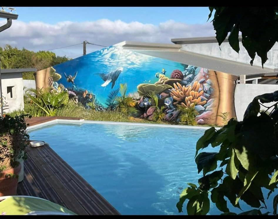 a painting of a swimming pool in front of a mural at la villa TIKALIKATA in Saint-Joseph