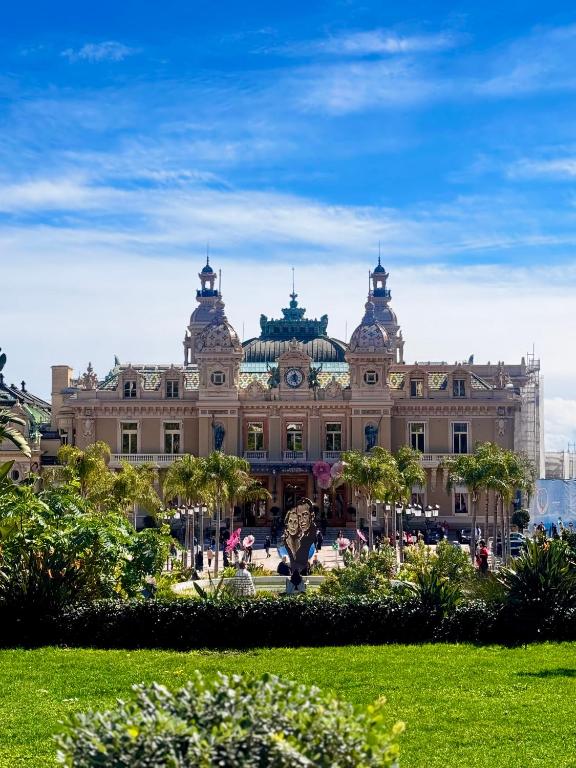 un grand bâtiment avec un parc en face dans l'établissement Appartement vue mer vue Monaco, à Beausoleil