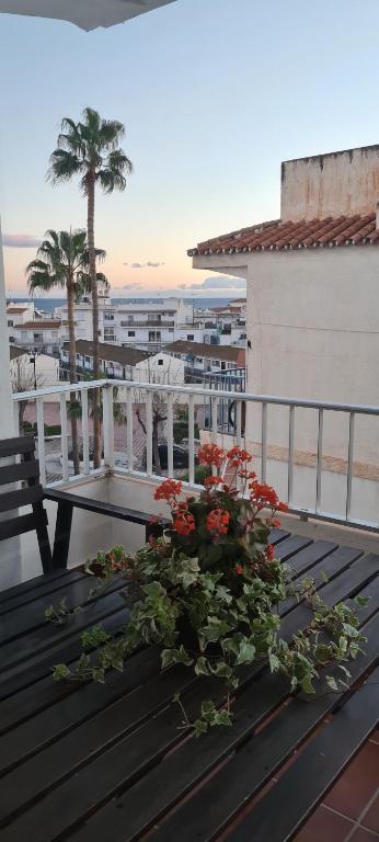 a table with flowers on top of a balcony at Apartamento Azul in Nerja
