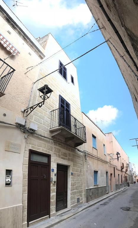 a building with a balcony on the side of a street at Favignana Holidays 4 in Favignana