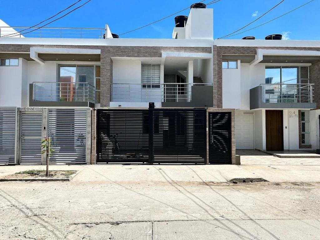 a large white house with a black gate at Apartamento moderno en Callejas – cómodo y bien ubicado in Valledupar