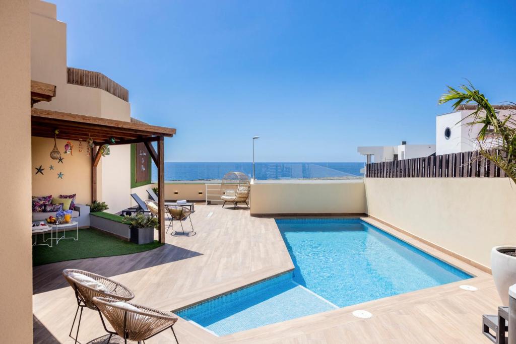 a swimming pool on the roof of a house at La Casa de Playa - piscina y jacuzzi a 50m del mar in El Médano