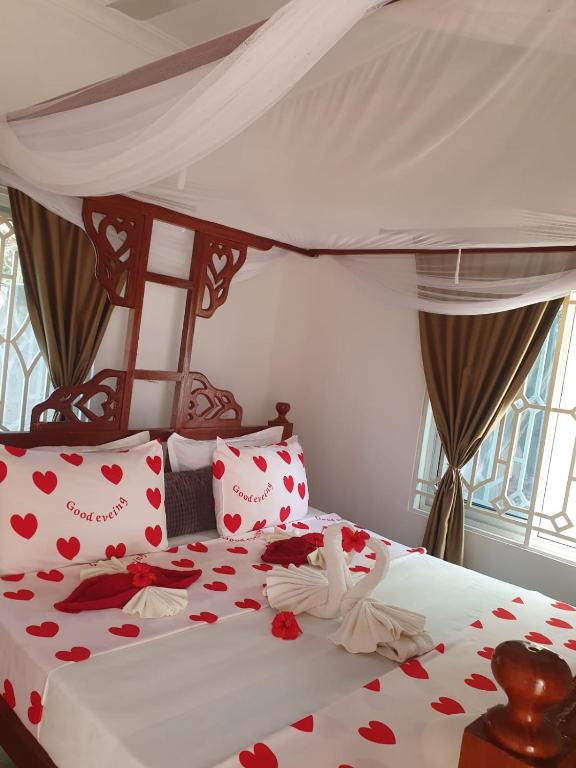 a bedroom with a bed with hearts on it at White Jaguar House in Bwejuu
