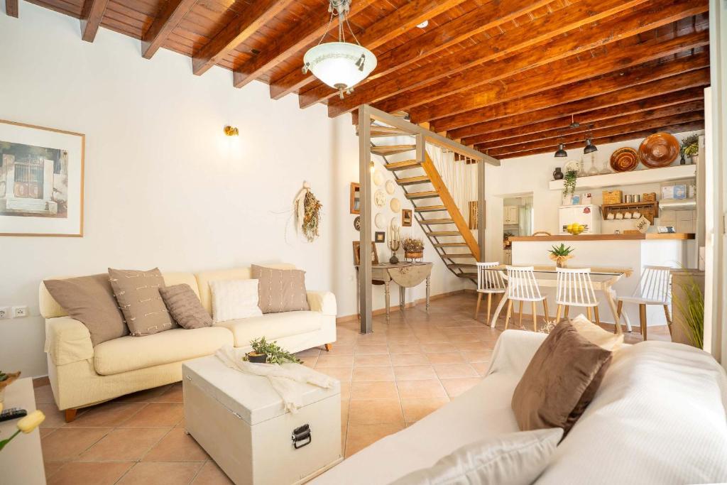 a living room with two couches and a staircase at OURANIAS HOUSE in Kalymnos