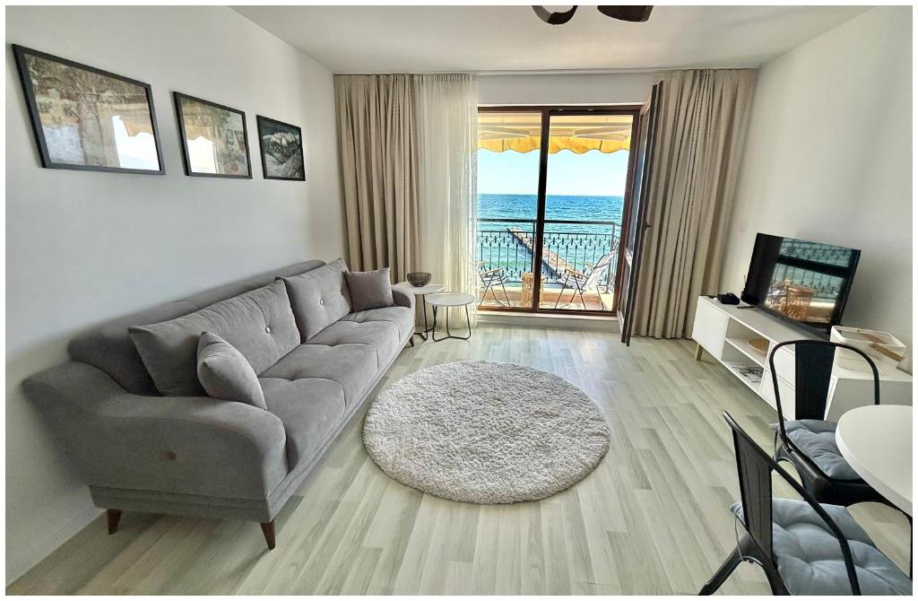 salon z kanapą i stołem w obiekcie Apartment Alegria complex Carpe Diem Balchik w Bałcziku