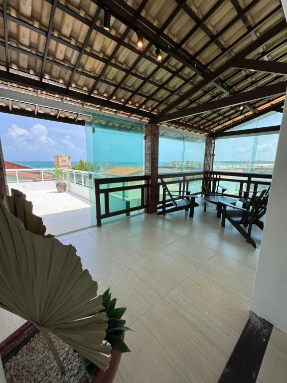 balcón con bancos y vistas al océano en Villa Kite House, en São Gonçalo do Amarante