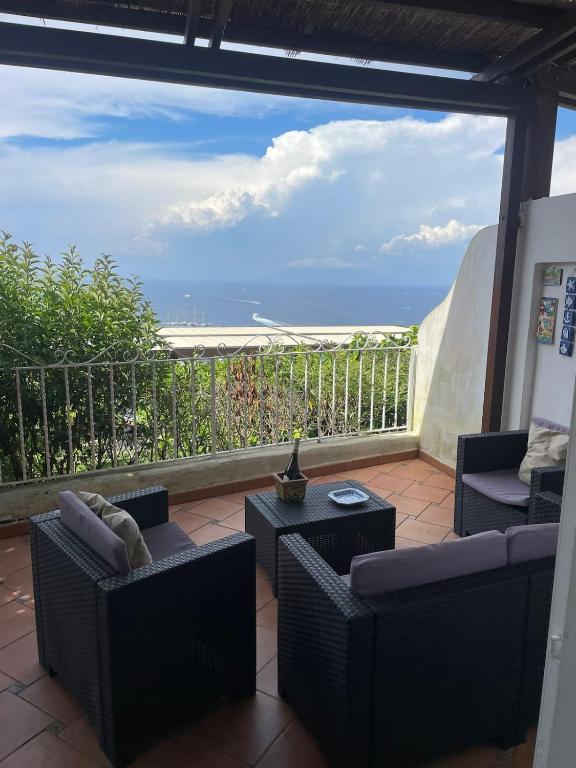 a patio with chairs and tables and a view of the ocean at La Casa di Audrey in Capri