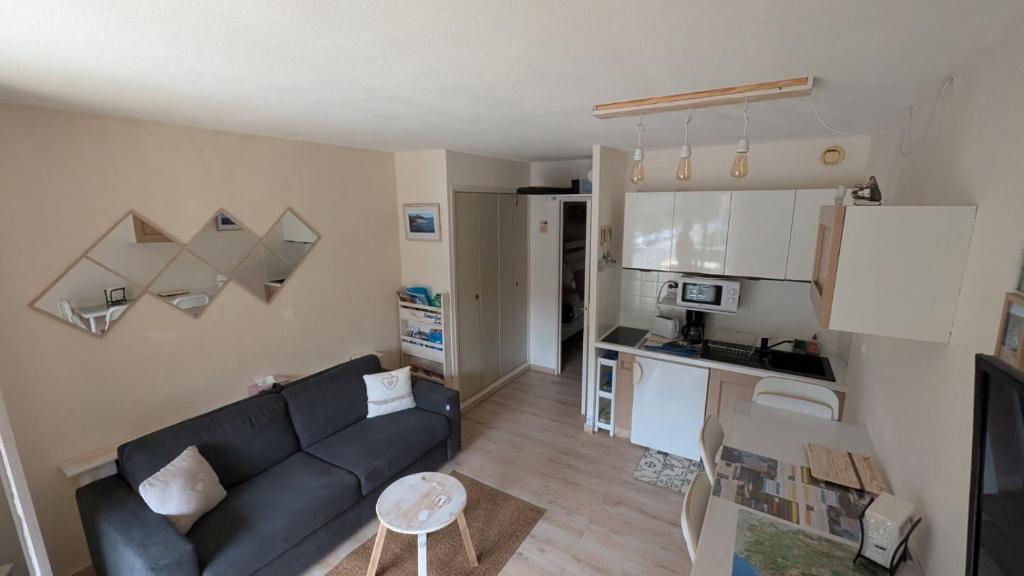 un salon avec un canapé et une cuisine dans l'établissement Saint Cyr-sur-mer la Madrague les AÏgues Marines, à Saint-Cyr-sur-Mer