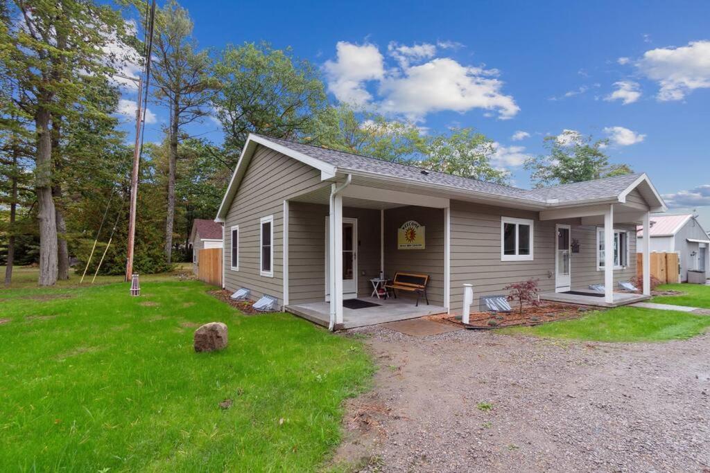 a small house with a porch and a yard at Cottages 7 & 9 - Fire Pit - Beach - Sleeps 8 in Lincoln Junction