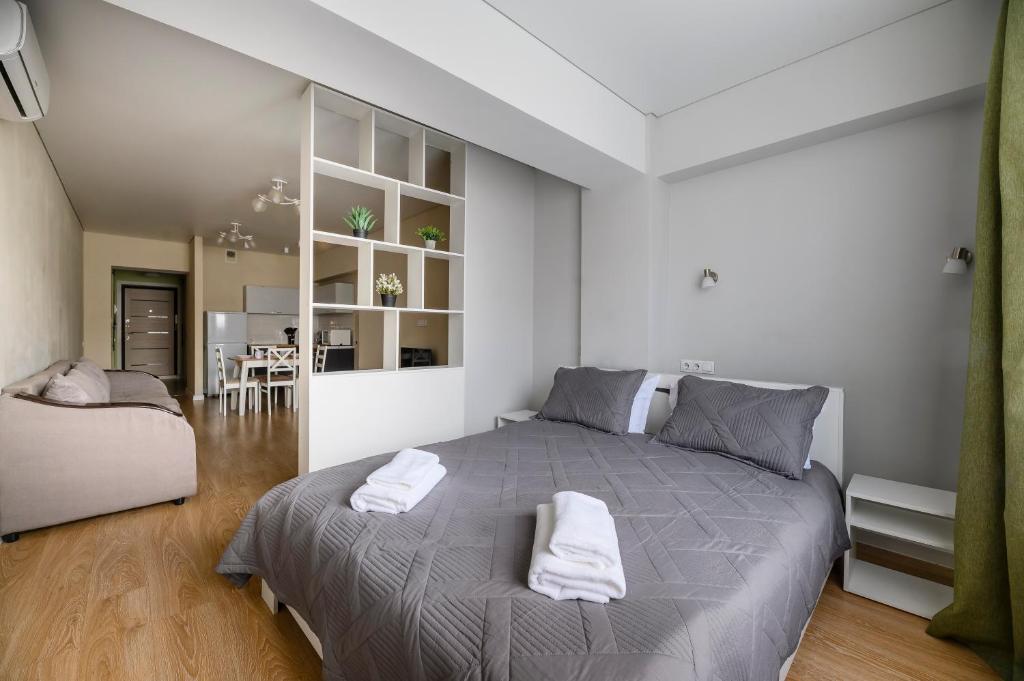 a bedroom with a large bed with towels on it at One Bedroom Apartment Near Arbat In The Golden Square of Almaty in Almaty