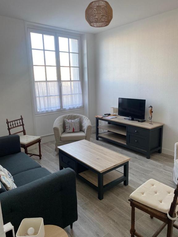 a living room with a couch and a tv at Appartement sur le port du Pouliguen in Le Pouliguen