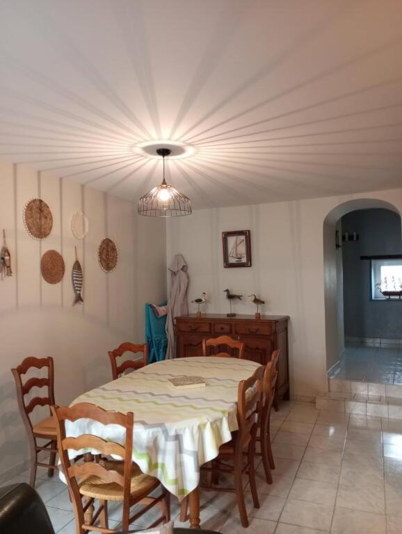 une salle à manger avec une table et des chaises dans l'établissement Maison avec courette à 400 m de la plage, à La Bernerie-en-Retz