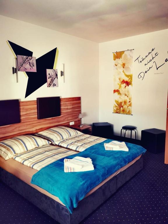 a bedroom with a large bed with blue sheets at Frühstück pension in Langenlebarn
