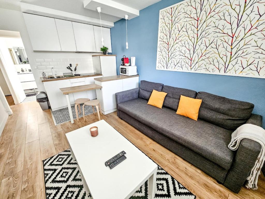 un salon avec un canapé et une table dans l'établissement Le Cosy - studio proche basilique saint Rémi, à Reims