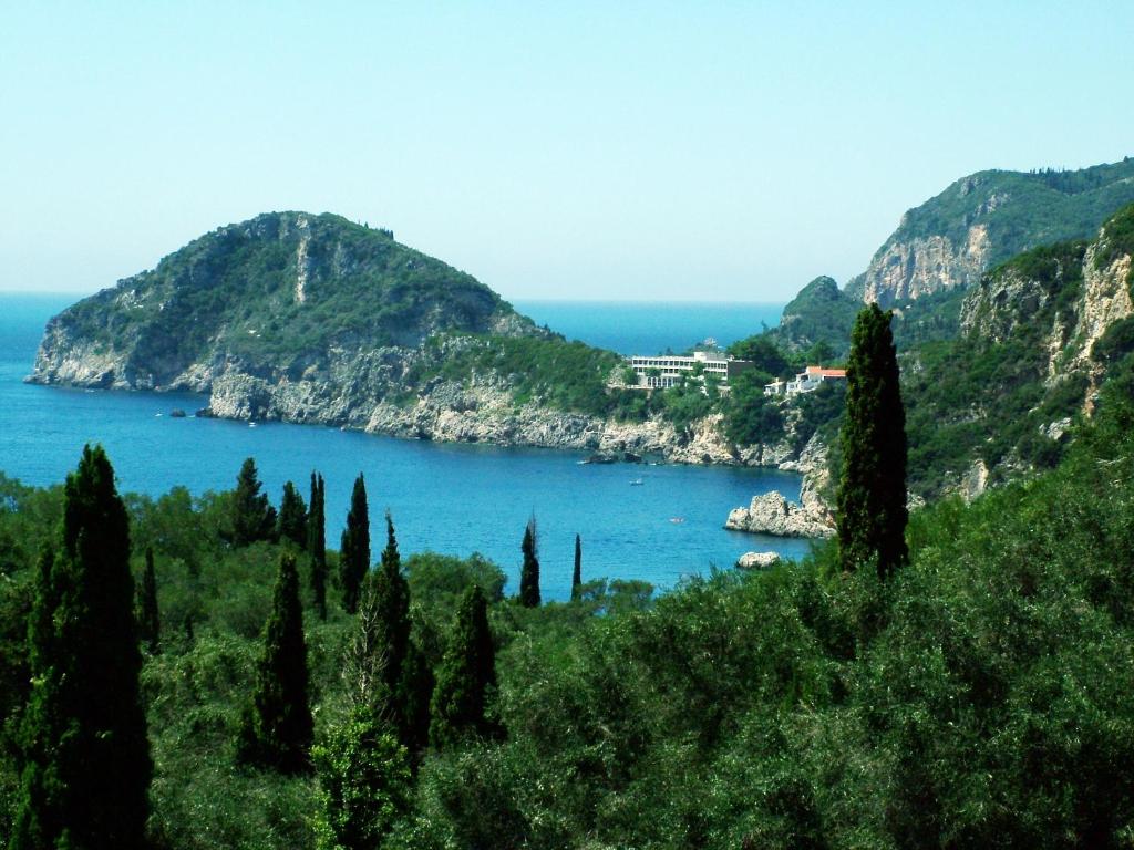 vista su una grande cassa d'acqua con alberi di Ponte Rossa Apartments a Paleokastritsa